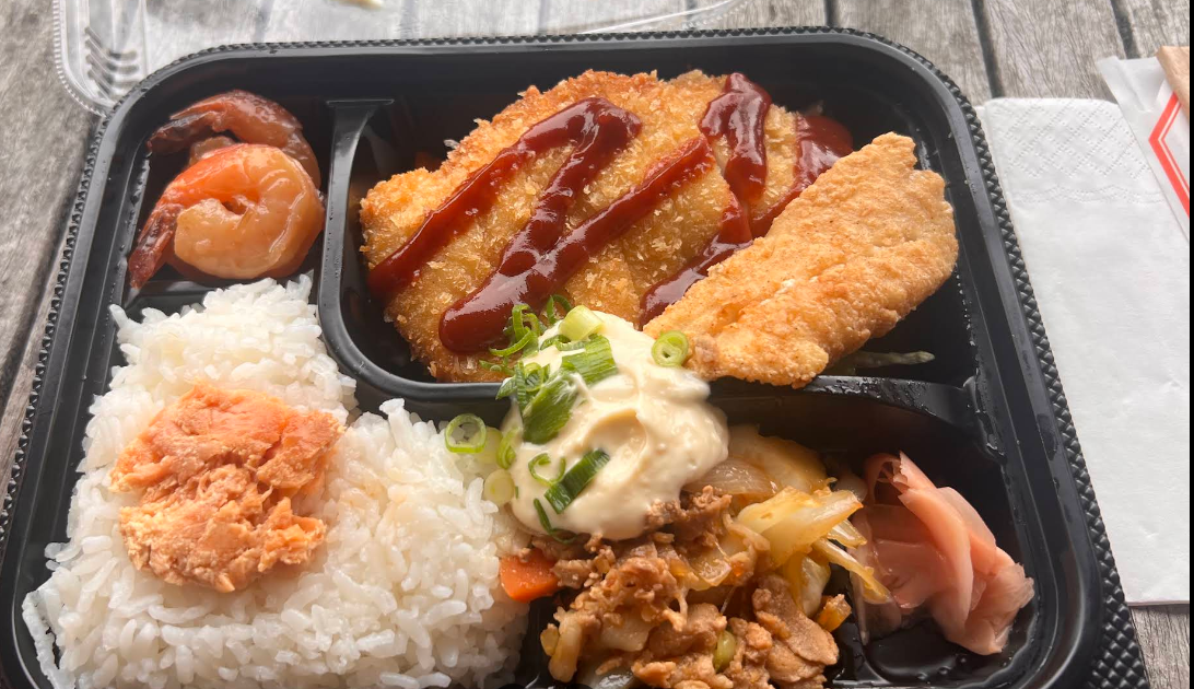 Bento box with crumbed chicken, rice, vegetables and sides